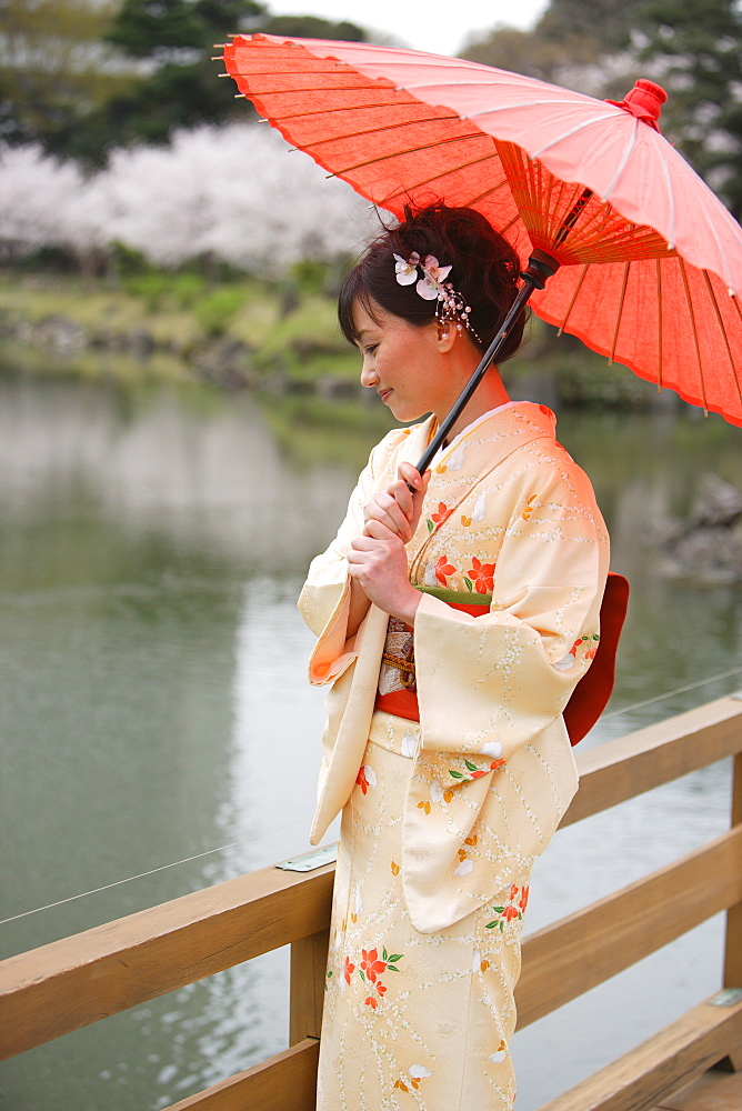 Woman Standing on Wooden Bridge Holding Parasol