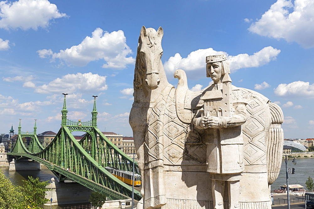 A statue of St Stephen in front of the Cave Church with a view of the Chain Bridge, Budapest, Hungary