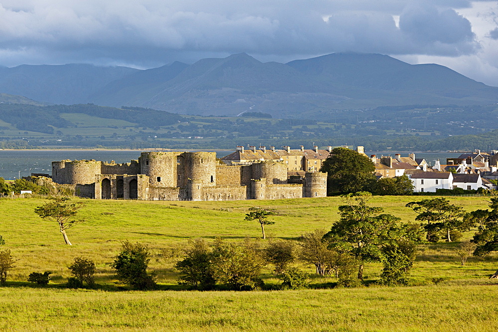 View of Beaumaris castle at Island of Anglesey with mountain ranges in background, Wales