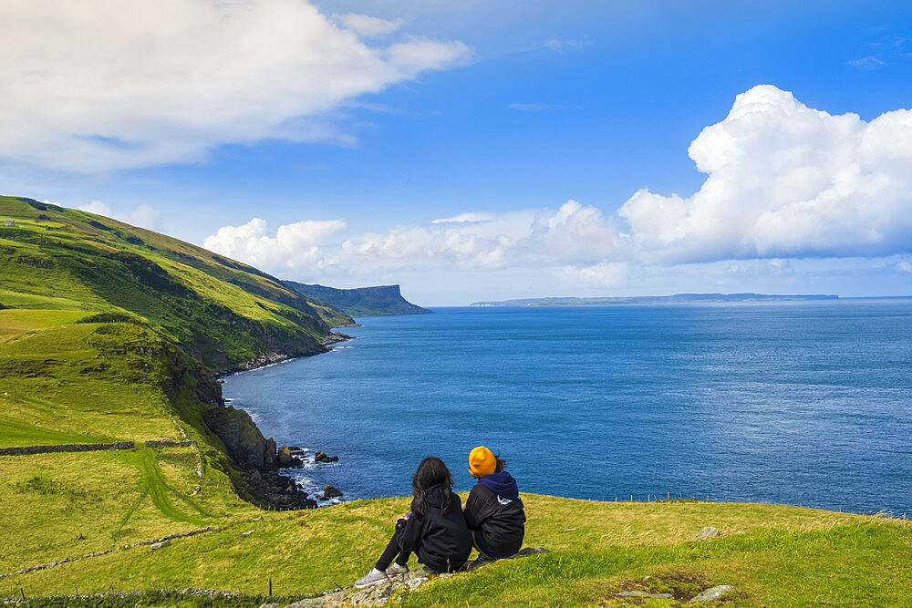 Two young hikers taking a rest on a walking trail along the Antrim coast, Ulster, Northern Ireland, United Kingdom, Europe