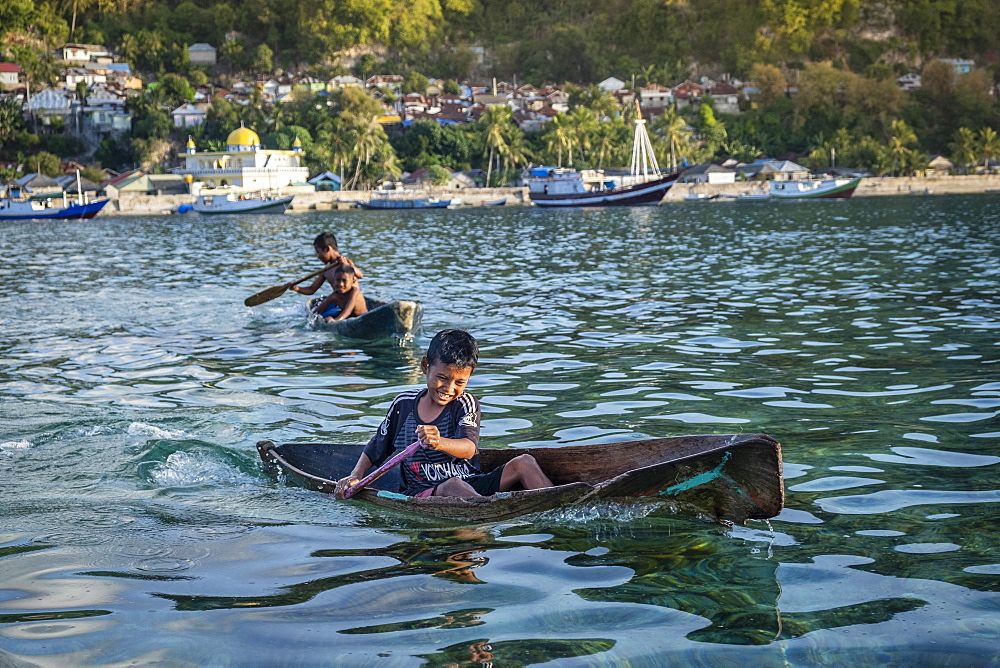 Local children in locally made dugout wooden canoes, Banda Besar, Maluku, Spice Islands, Indonesia, Southeast Asia, Asia