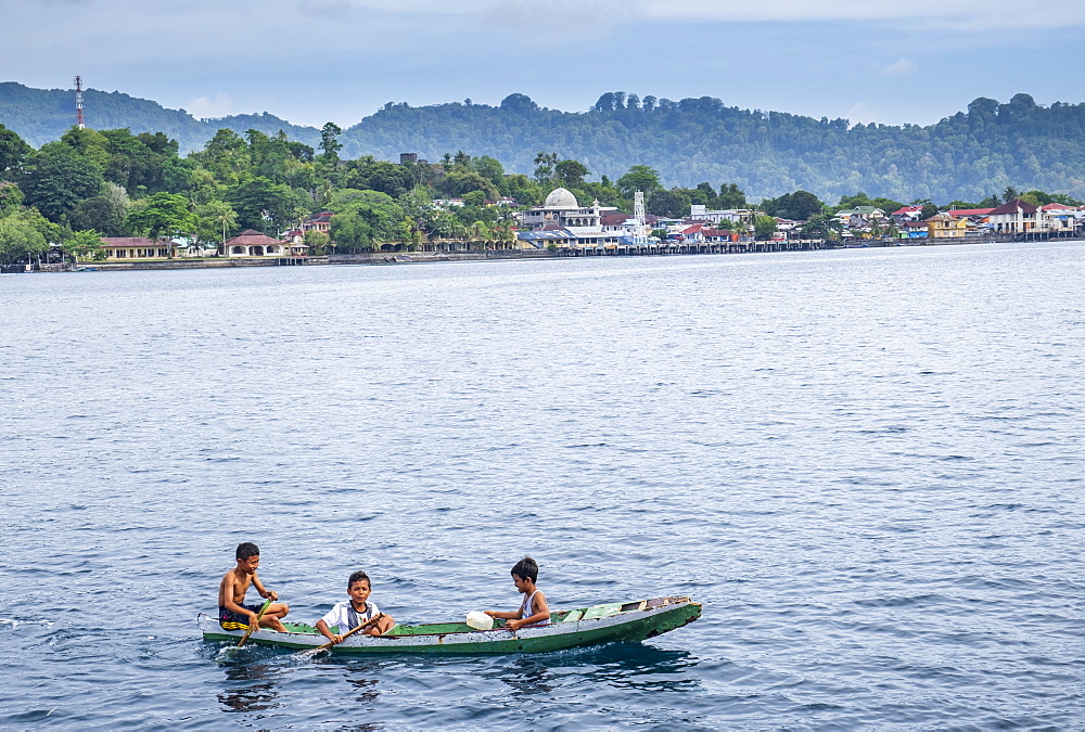 Local boys in a wooden canoe, Rhun, Banda Islands, Maluku, Spice Islands, Indonesia, Southeast Asia, Asia