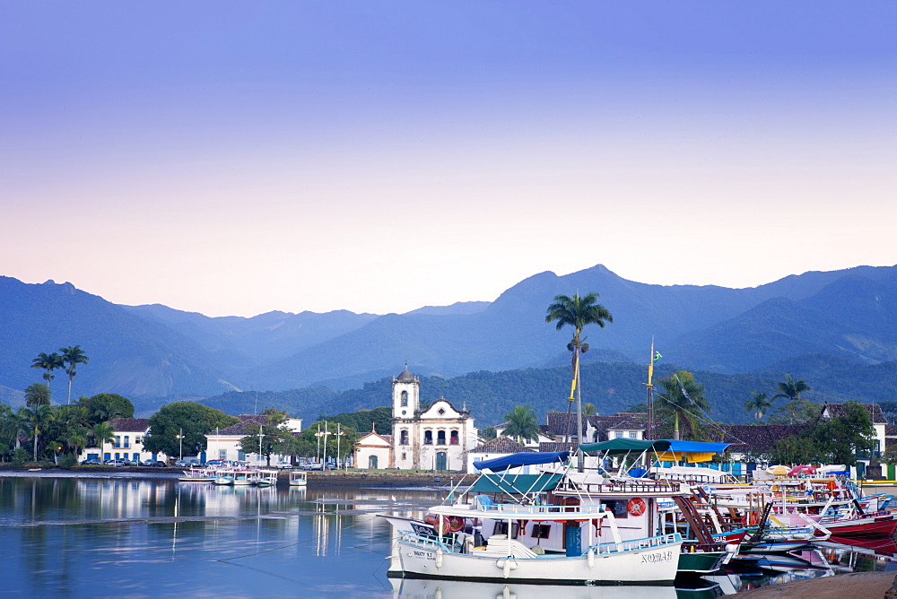 Docks at Paraty with the Serra da Bocaina mountains behind and the church of Nossa Senhora dos Remedios, Rio de Janeiro State, Brazil, South America