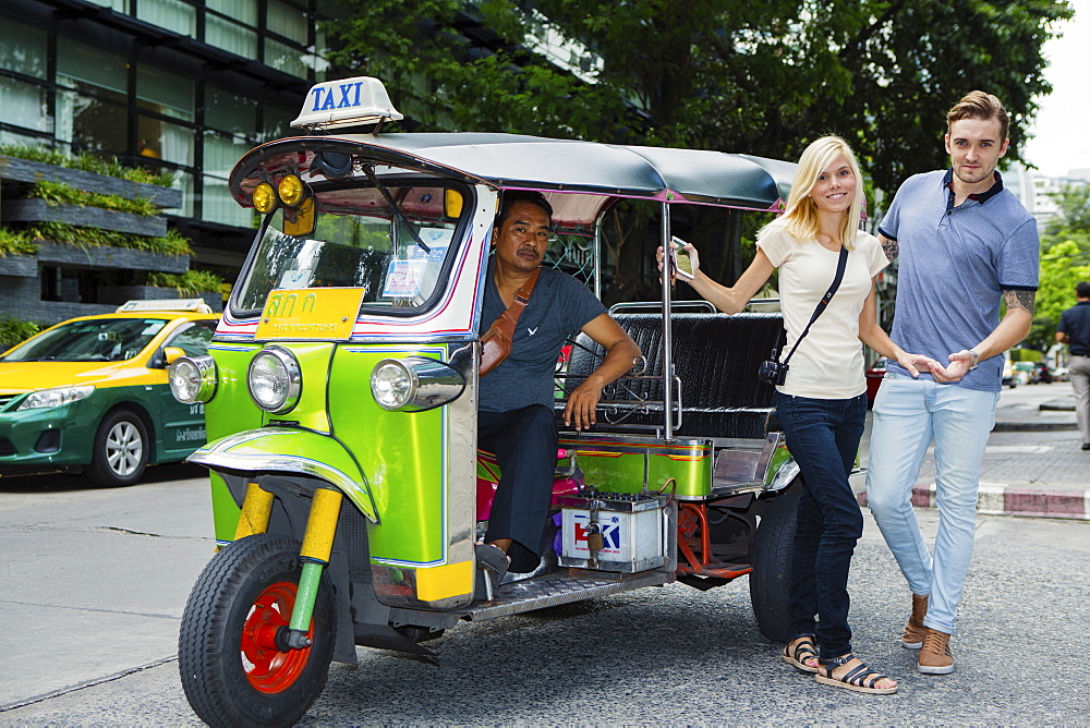 Tourists catching a Tuk-tuk near Khao San road in Bangkok, Thailand, Southeast Asia, Asia