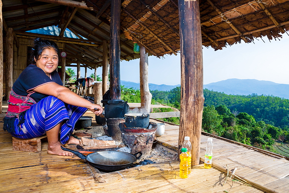 Indigenous White Karen (Kayin) hill tribe villager cooking at a traditional stove in a mountain village near Doi Inthanon, Chiang Mai, Thailand, Southeast Asia, Asia