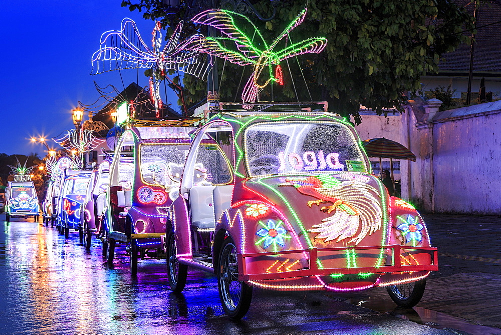 Brightly coloured illuminated pedal cars in Yogyakarta city, Java, Indonesia, Southeast Asia, Asia