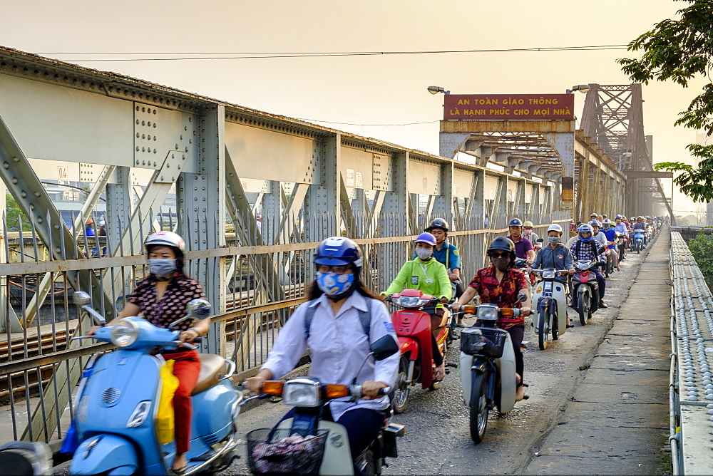 Motorbike commuters on a pedestrian pavement (sidewalk) on a railway bridge over the Red River in Hanoi, Vietnam, Indochina, Southeast Asia, Asia