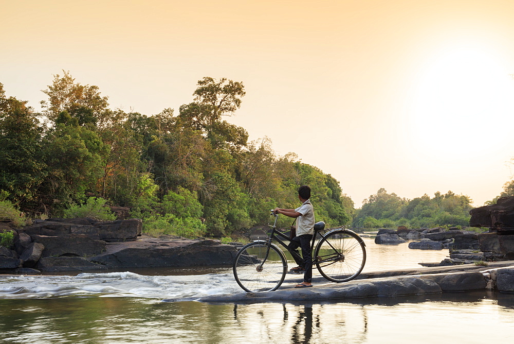 School boy on a bicycle crossing a river on his way to school, Chi Phat, Koh Kong, Cambodia, Indochina, Southeast Asia, Asia