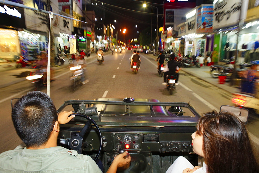 A Vietnamese couple in an open-top Jeep driving through the streets of Hue, Vietnam, Indochina, Southeast Asia, Asia