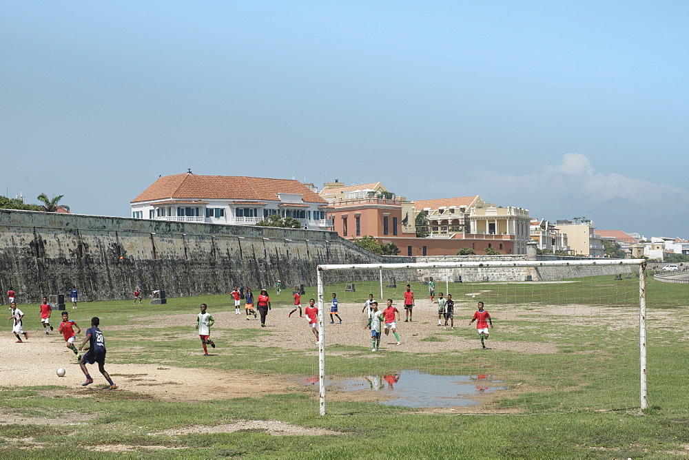 Children playing football outside the Spanish colonial city walls of Cartagena in the Colombian Caribbean, Cartagena, Colombia, South America