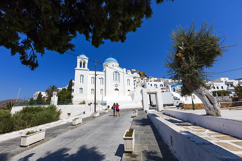 Tourists admire the architecture of Orthodox churches colored white and blue as symbols of Greece, Ios, Cyclades, Greek Islands, Greece, Europe