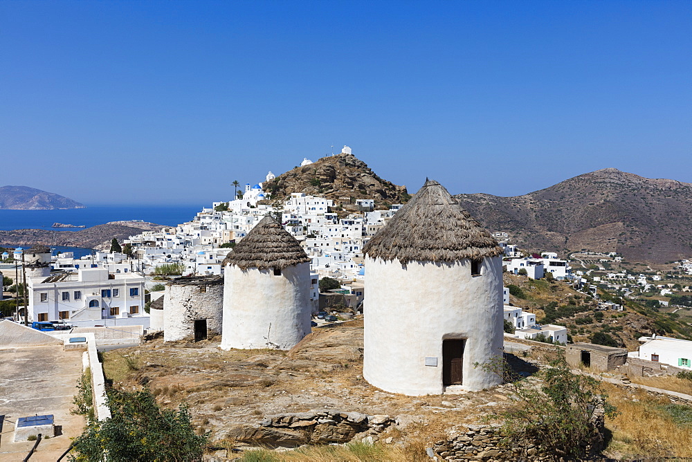 A typical Greek village perched on a rock with white and blue houses and quaint windmills, Ios, Cyclades, Greek Islands, Greece, Europe