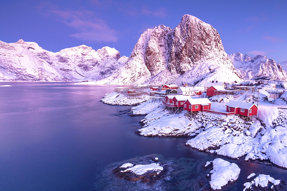 Pink sunrise on snowy peaks surrounded by the frozen sea around the village of Hamnoy, Nordland, Lofoten Islands, Arctic, Norway, Scandinavia, Europe