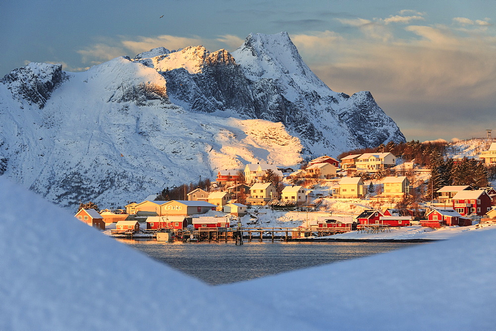 The last rays of sun on the fishing village and the snowy peaks, Kvalvika, Andoya, Reine, Nordland, Lofoten Islands, Arctic, Norway, Scandinavia, Europe