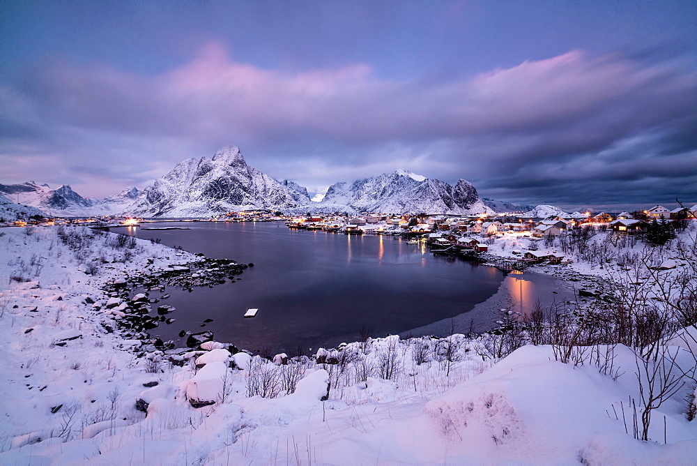 Colors of dawn on the fishing village surrounded by snowy peaks and frozen sea, Reine, Nordland, Lofoten Islands, Arctic, Norway, Scandinavia, Europe