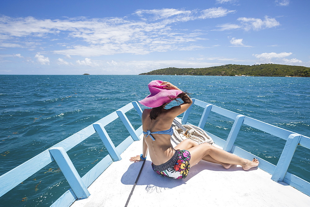 A tourist admires the colors of Caribbean Sea from a boat, Green Island, Antigua and Barbuda, Leeward Islands, West Indies, Caribbean, Central America