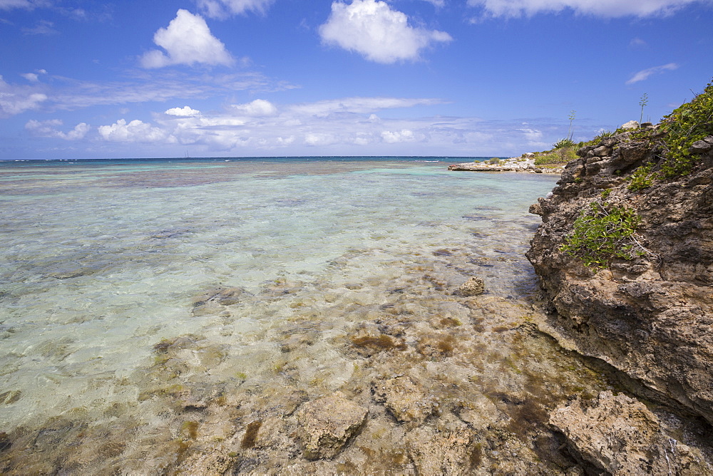 The turquoise shades of the Caribbean Sea seen from the cliffs of Green Island, Antigua and Barbuda, Leeward Islands, West Indies, Caribbean, Central America