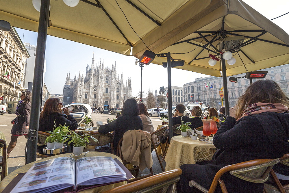 Tourists in the cafe contemplate the Duomo and its square, Milan, Lombardy, Italy, Europe