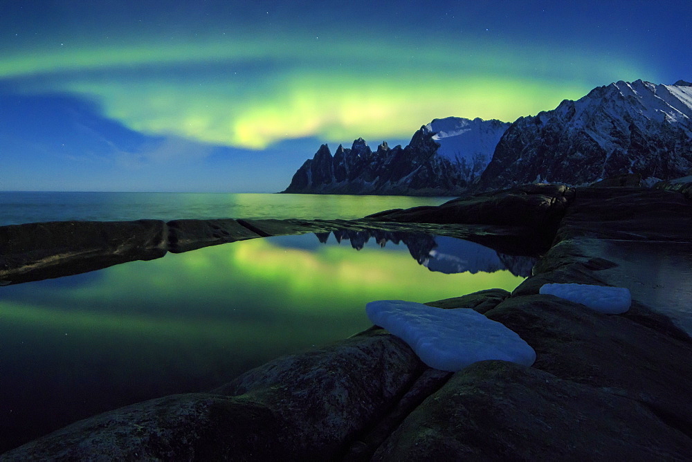 The Northern Lights (aurora borealis) and stars reflected in the icy sea, Tungeneset, Senja, Troms county, Arctic, Norway, Scandinavia, Europe