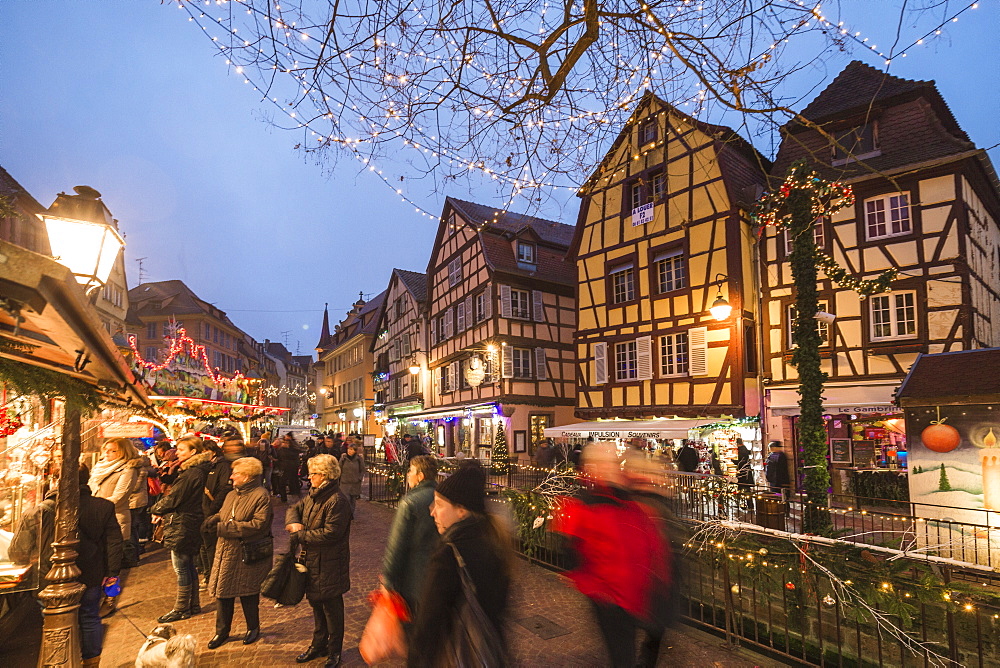 Tourists shopping at the Christmas Markets in the old medieval town of Colmar, Haut-Rhin department, Alsace, France, Europe