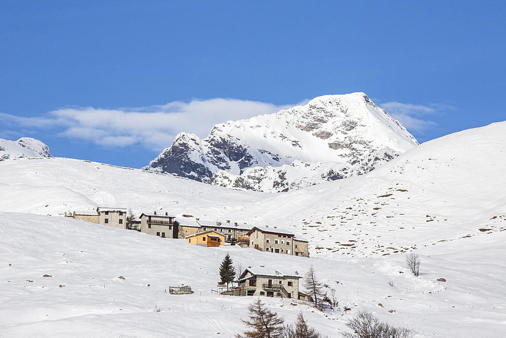 The snowy huts frame Peak Tambo in the background, Andossi, Spluga Valley, Province of Sondrio, Valtellina, Lombardy, Italy, Europe