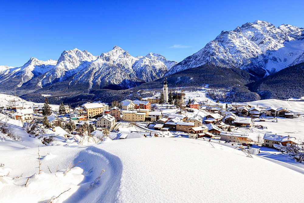 Blue sky on the alpine village of Ftan surrounded by snow, Inn district, Canton of Graubunden, Engadine, Swiss Alps, Switzerland, Europe