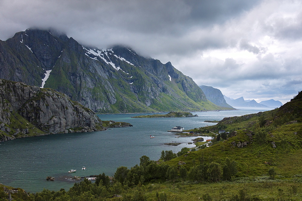 Blue lights and clouds on the calm sea surrounded by rocky peaks at night, Tangstadpollen, Vestvagoy, Lofoten Islands, Norway, Scandinavia, Europe