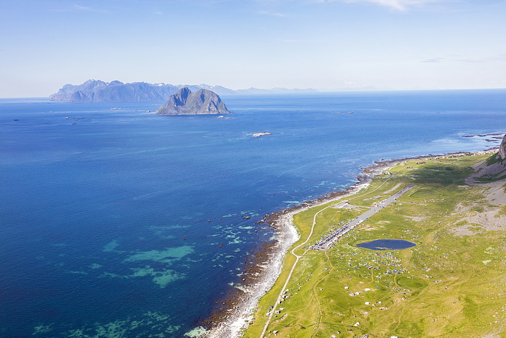 Tents in the green meadows surrounded by blue lake and sea, Vaeroy Island, Nordland county, Lofoten archipelago, Norway, Scandinavia, Europe