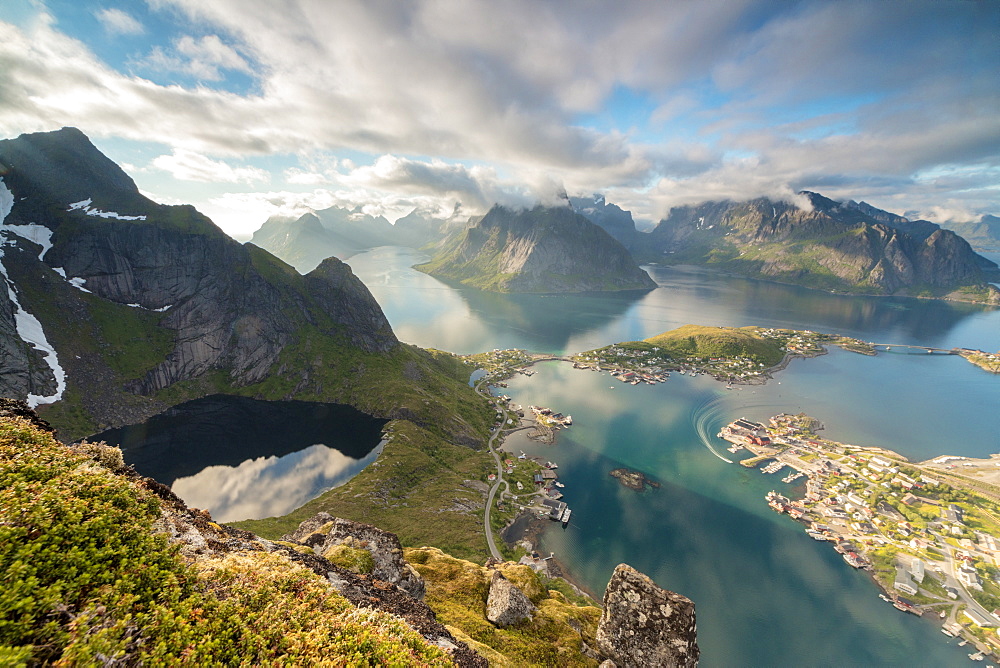 Clouds reflected in blue lake and sea framed by rocky peaks, Reinebringen, Moskenesoya, Lofoten Islands, Norway, Scandinavia, Europe