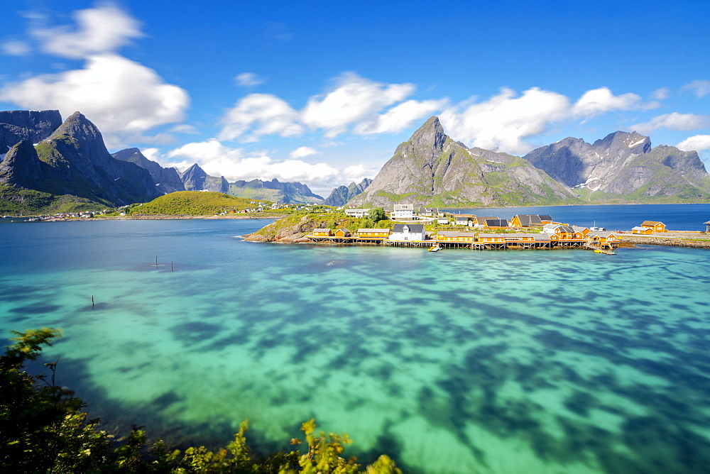 The turquoise sea frames the typical fishing village surrounded by rocky peaks, Sakrisoy, Reine, Moskenesoya, Lofoten Islands, Norway, Scandinavia, Europe