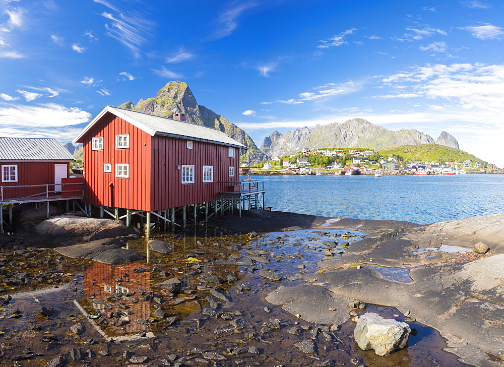 Typical house of fishermen called Rorbu reflected in blue sea, Reine, Moskenesoya, Lofoten Islands, Norway, Scandinavia, Europe