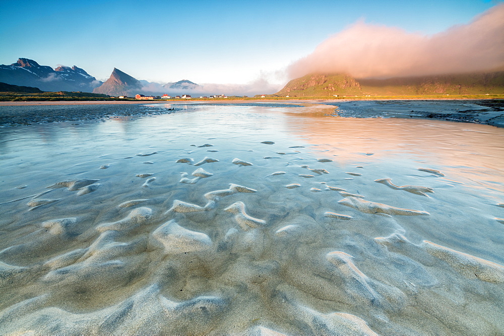 High peaks and midnight sun are reflected in the cold sea, Fredvang, Moskenesoya, Nordland county, Lofoten Islands, Norway, Scandinavia, Europe