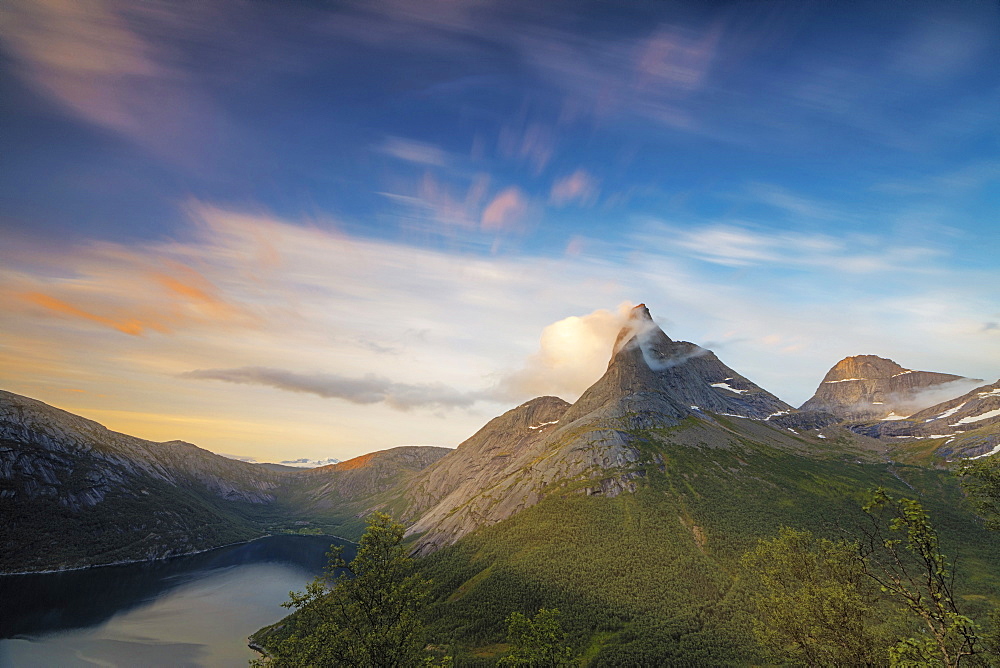 Pink sky and midnight sun light up the rocky peak of the Stetinden mountain surrounded by sea, Tysfjord, Nordland, Norway, Scandinavia, Europe