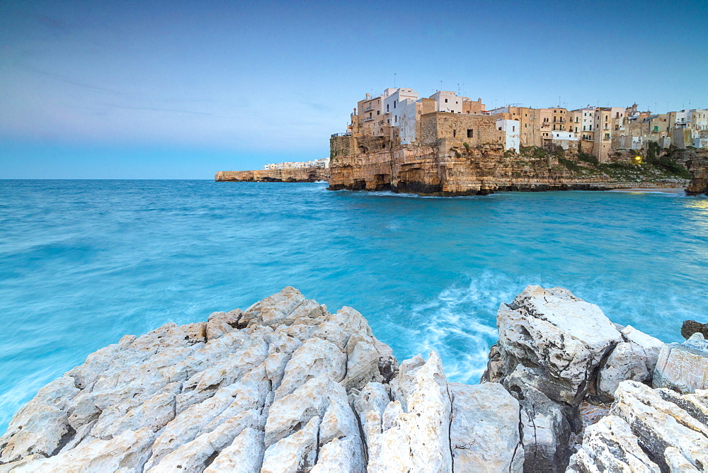 Turquoise sea at dusk framed by the old town perched on the rocks, Polignano a Mare, Province of Bari, Apulia, Italy, Europe