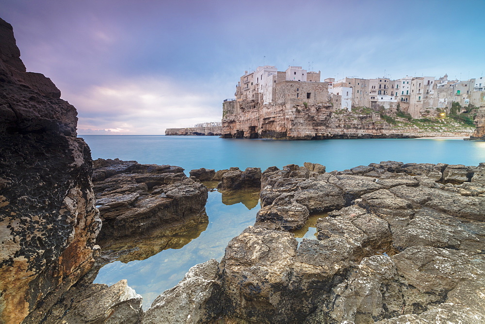 Turquoise sea at sunrise framed by the old town perched on the rocks, Polignano a Mare, Province of Bari, Apulia, Italy, Europe