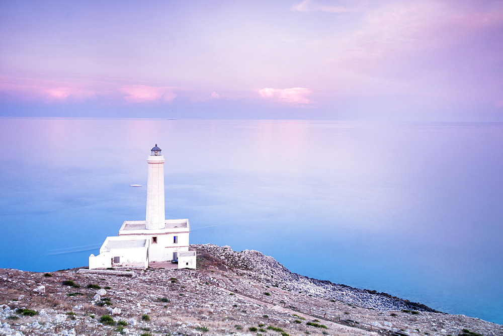 Pink sky on turquoise sea frames the lighthouse at Punta Palascia at sunset, Otranto, Province of Lecce, Apulia, Italy, Europe