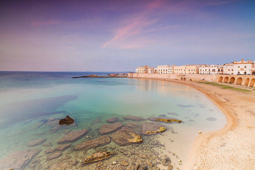 Turquoise sea frames the beach and the medieval old town at sunset Gallipoli, Province of Lecce, Apulia, Italy, Europe