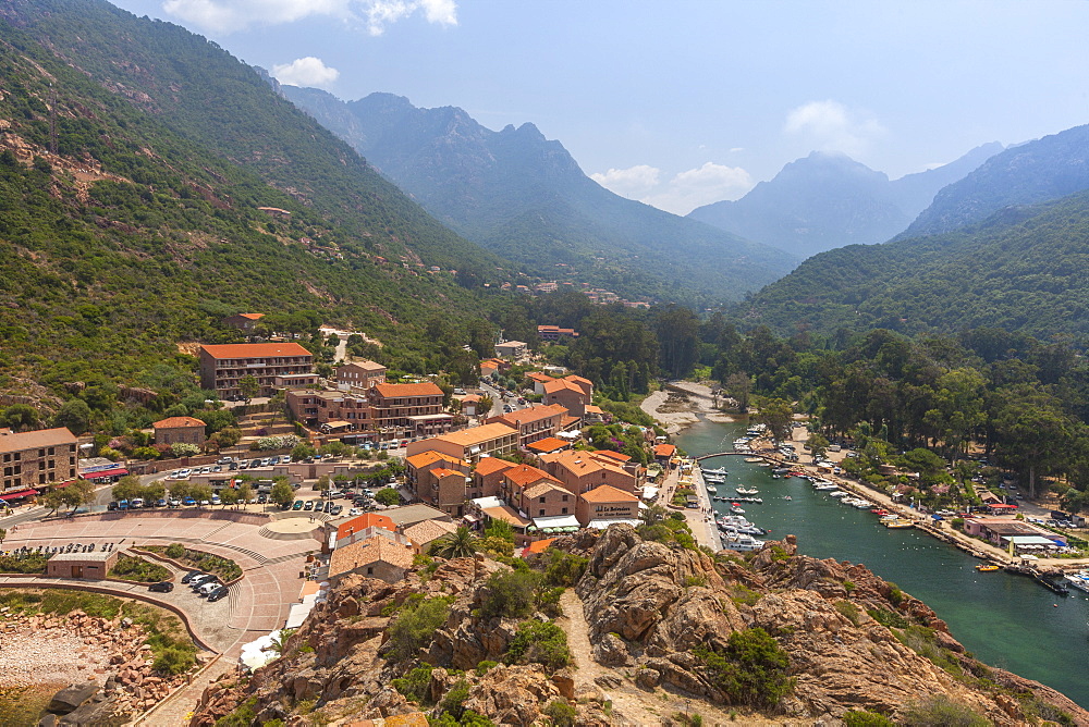 The typical village and harbor of Porto immersed in the green vegetation of the promontory, Southern Corsica, France, Mediterranean, Europe