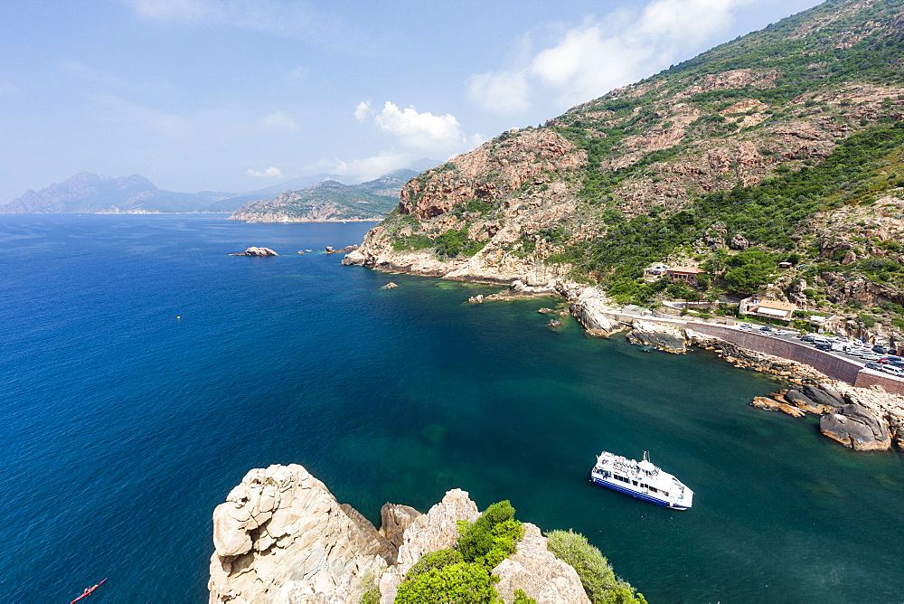 Tourist boat in the turquoise sea framed by limestone cliffs, Porto, Southern Corsica, France, Mediterranean, Europe