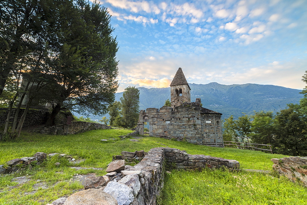 Green meadows frame the Abbey of San Pietro in Vallate at sunset, Piagno, Sondrio province, Lower Valtellina, Lombardy, Italy, Europe