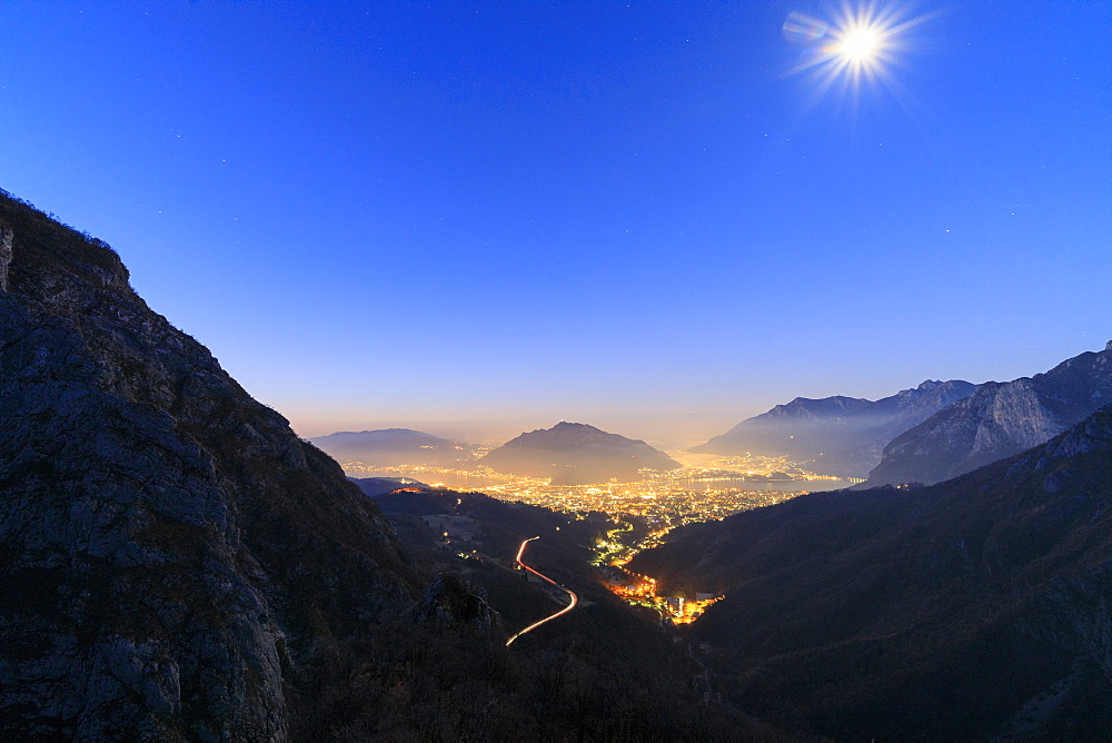 Dusk on the illuminated city of Lecco seen from the road to Morterone, Lombardy, Italy, Europe