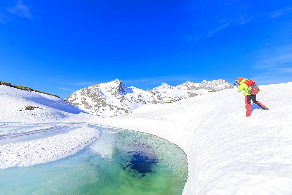 Photographer at the Bernina Pass during the spring thaw, St Moritz, Upper Engadine, Canton of Graubunden, Switzerland, Europe