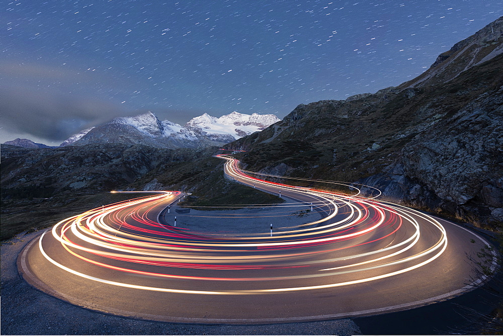 Star trail and lights of car traces, Bernina Pass, Poschiavo Valley, Engadine, Canton of Graubunden, Switzerland, Europe