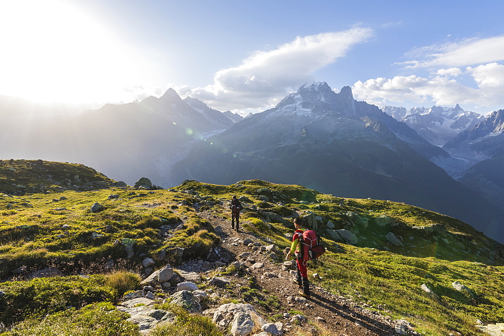 Hikers on the way to Lacs De Cheserys from Argentiere with Les Drus and Aiguille Verte in the background, Haute Savoie, French Alps, France, Europe