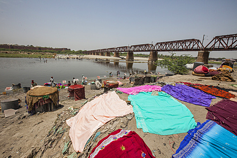 Colorful clothes drying in the sun on the banks of the River Yamuna, a polluted tributary of the Ganges, New Delhi, India, Asia