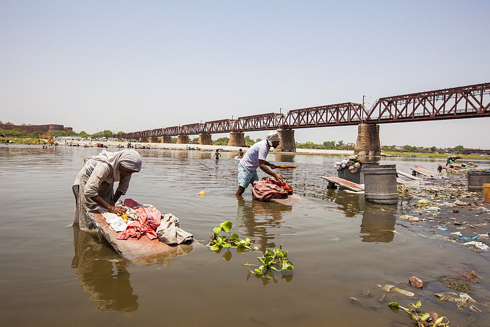 Women wash clothes in the polluted water of the Yamuna River, a tributary of the Ganges, New Delhi, India, Asia