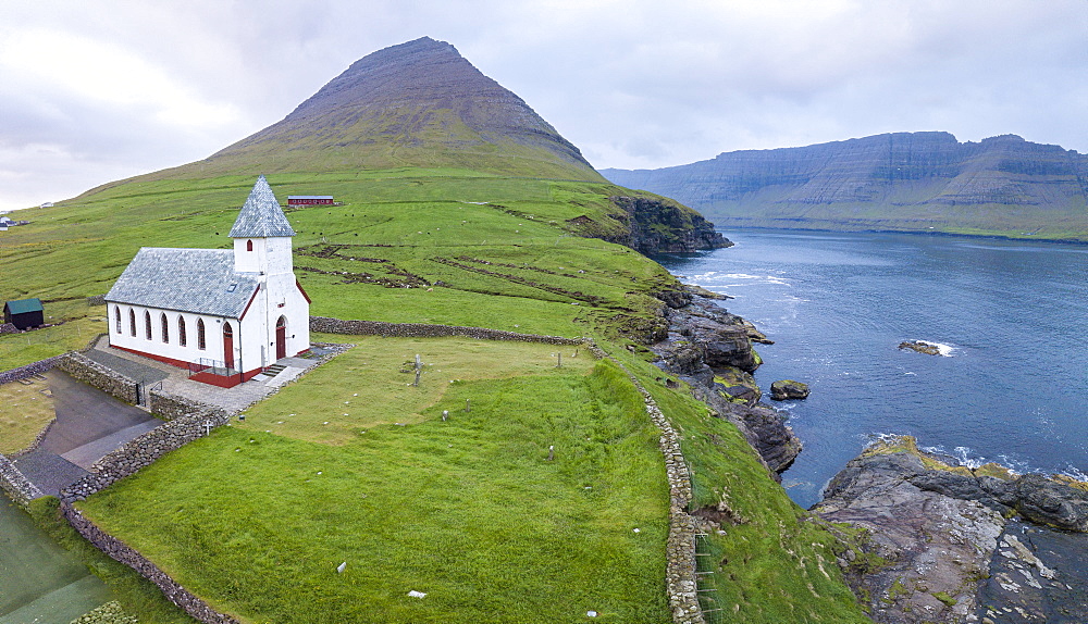 Panoramic of Church of Vidareidi by the sea, Vidoy Island, Faroe Islands, Denmark, Europe (Drone)