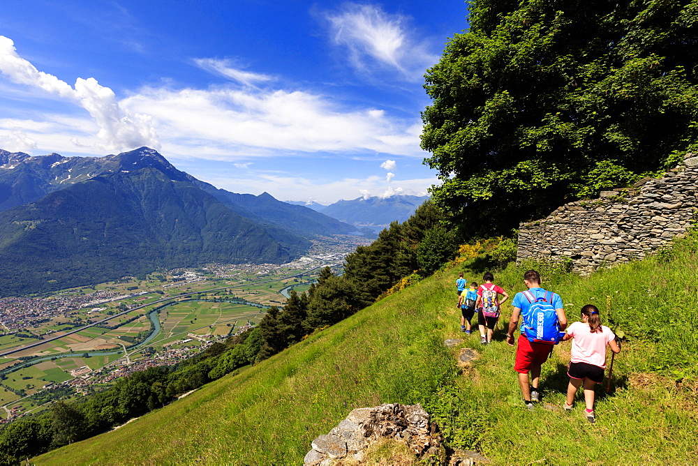 Family with children walk on footpath to Alpe Bassetta, Lower Valtellina, Sondrio province, Lombardy, Italy, Europe