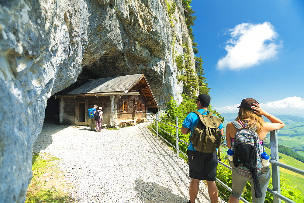 Hikers on walkway to the ancient caves, Wildkirchli, Ebenalp, Appenzell Innerrhoden, Switzerland, Europe