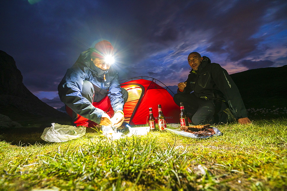 Hikers having meal outside tent at lake Riffelsee, Zermatt, canton of Valais, Switzerland, Europe